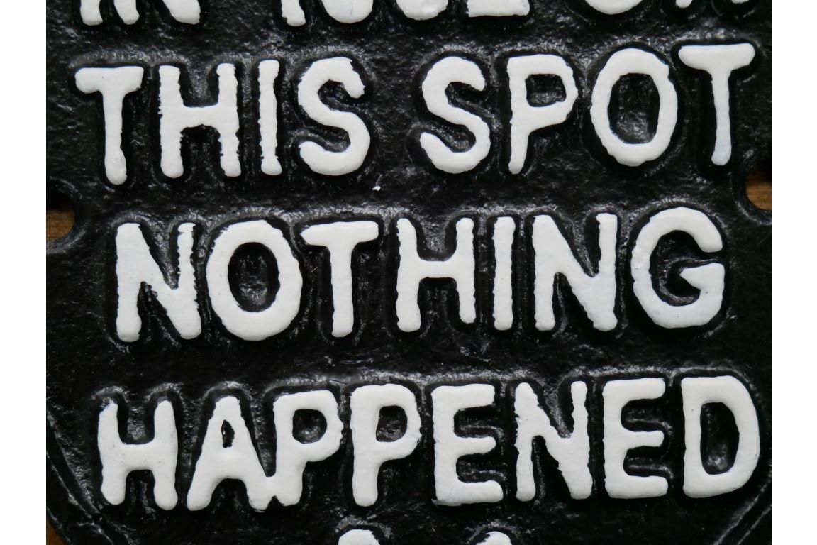 Humorous Emblem Shaped Sign in Black Iron Close-Up