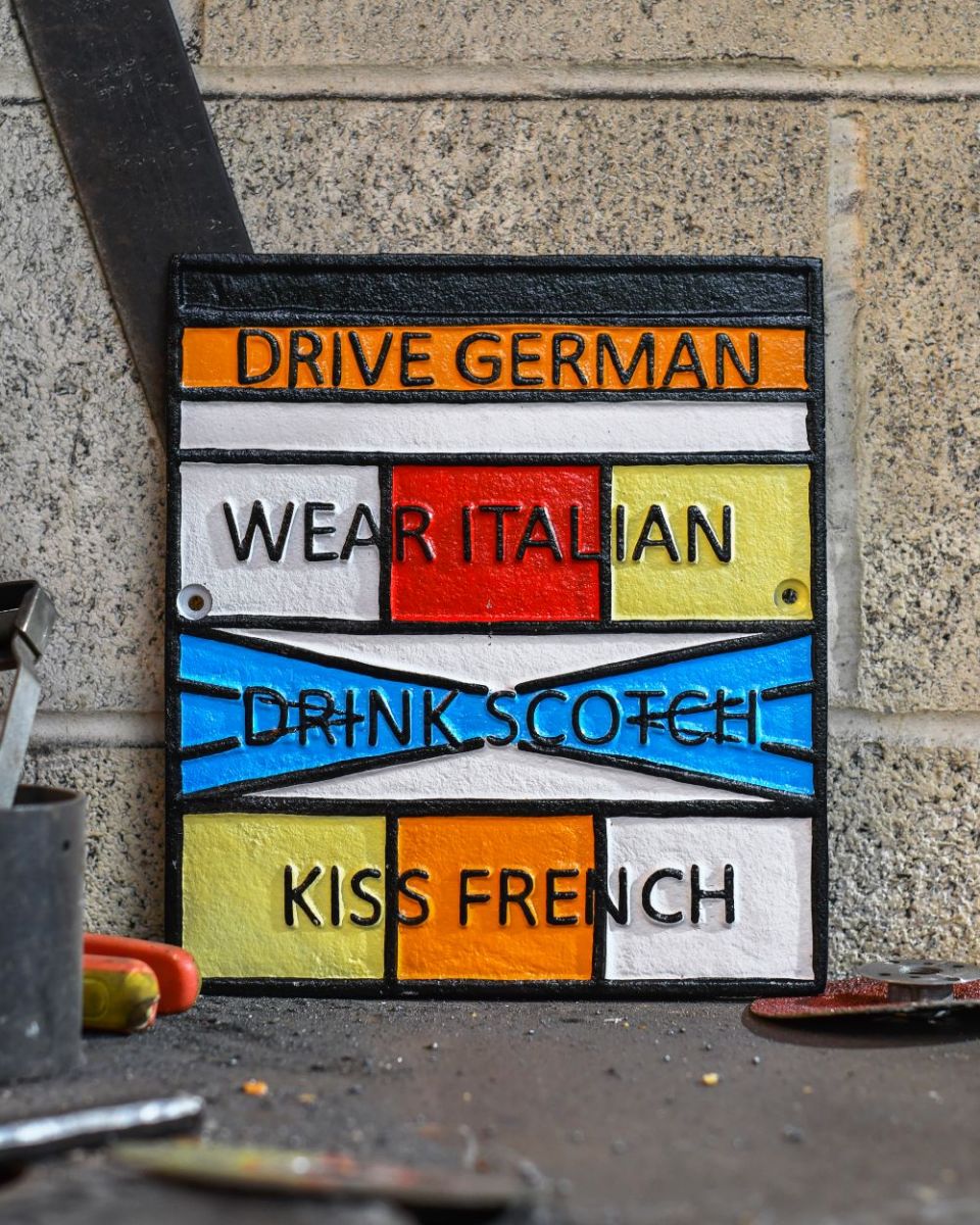 "Drive German, Wear Italian, Drink Scotch, Kiss French" Cast Iron Sign