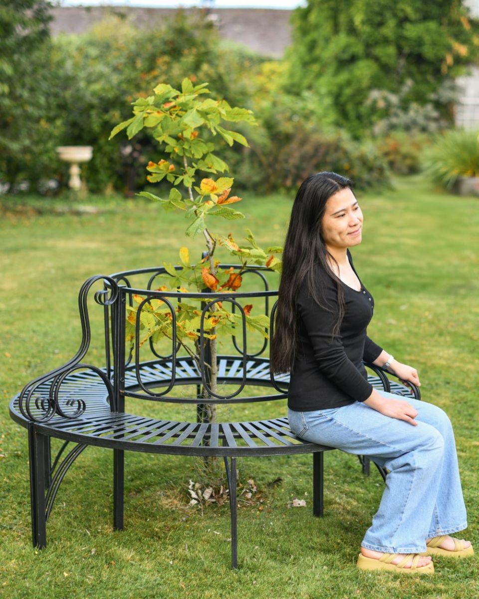 Scale image of intricate black tree bench