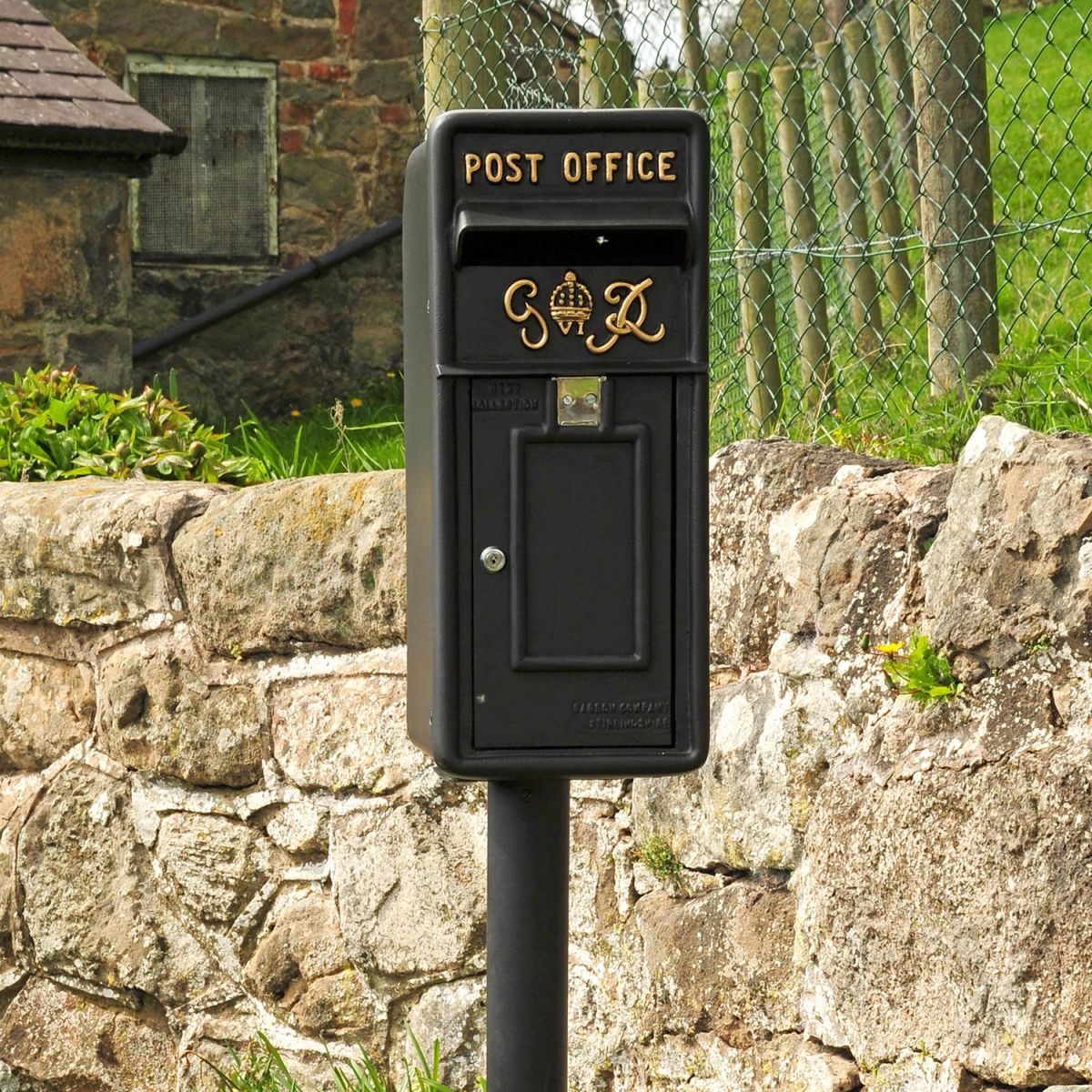 King George Rex Black Period Post Box by a Stone Wall