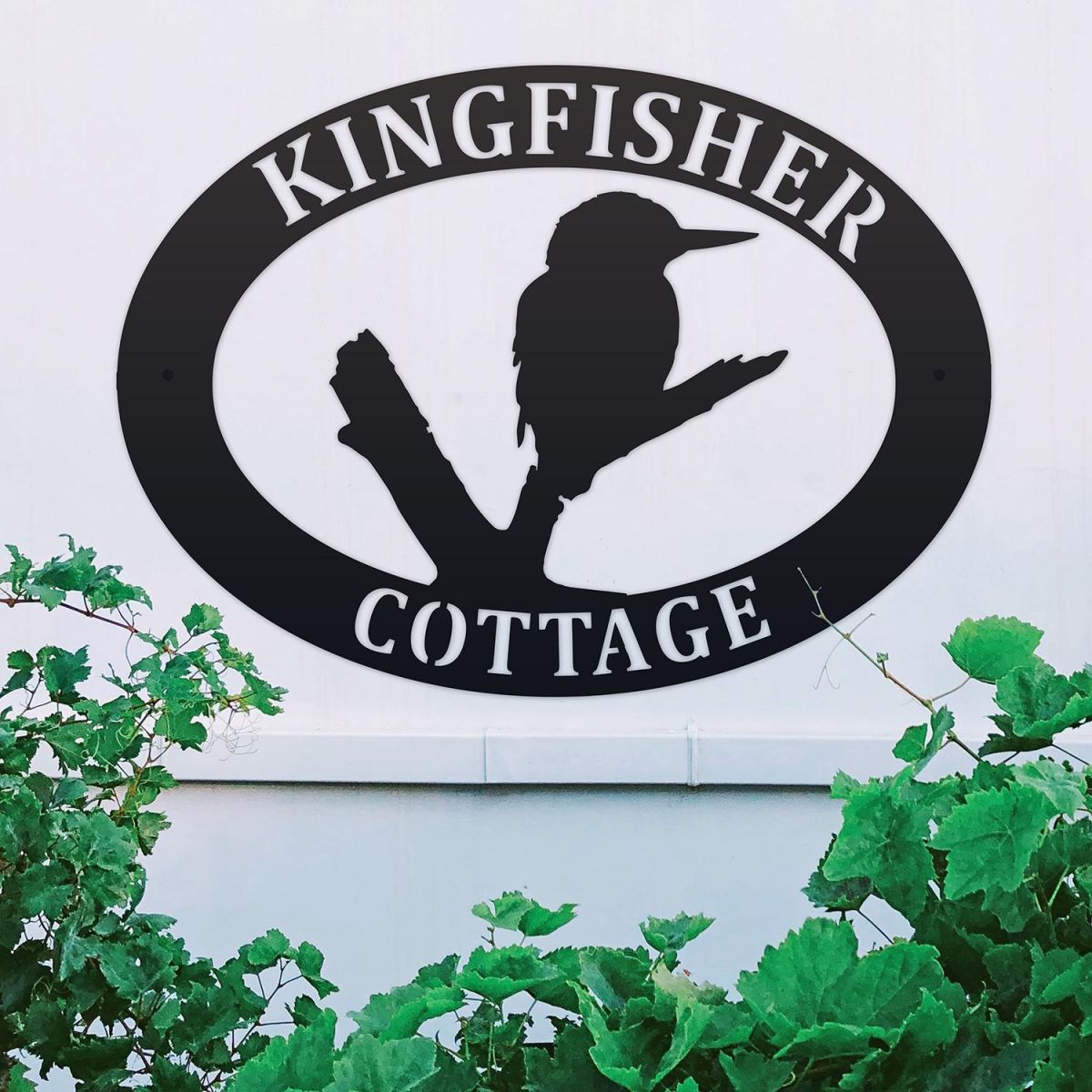 Kingfisher Iron Oval House Sign on a White Wall