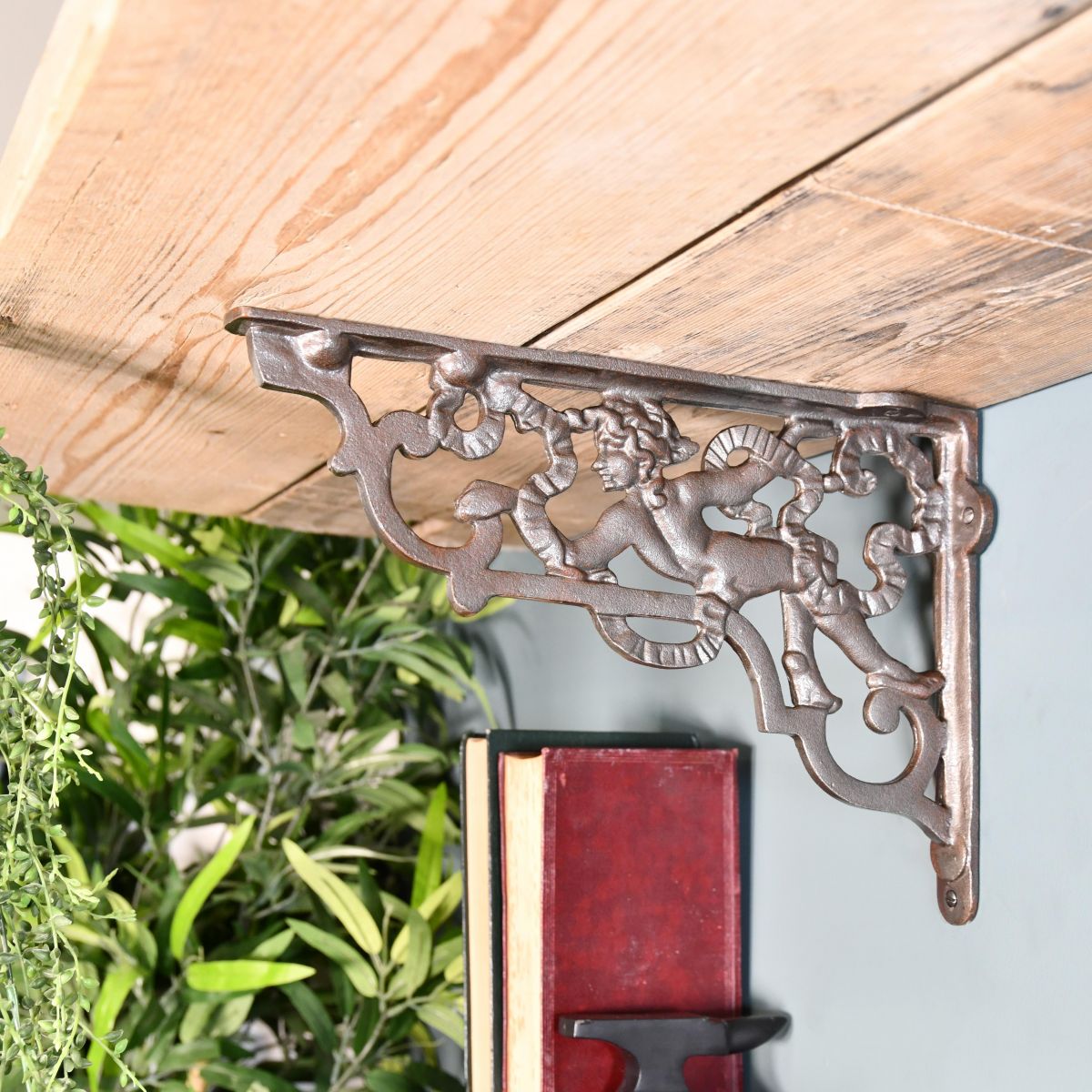 Cherub Iron Shelf Bracket Holding up a Wooden Shelf