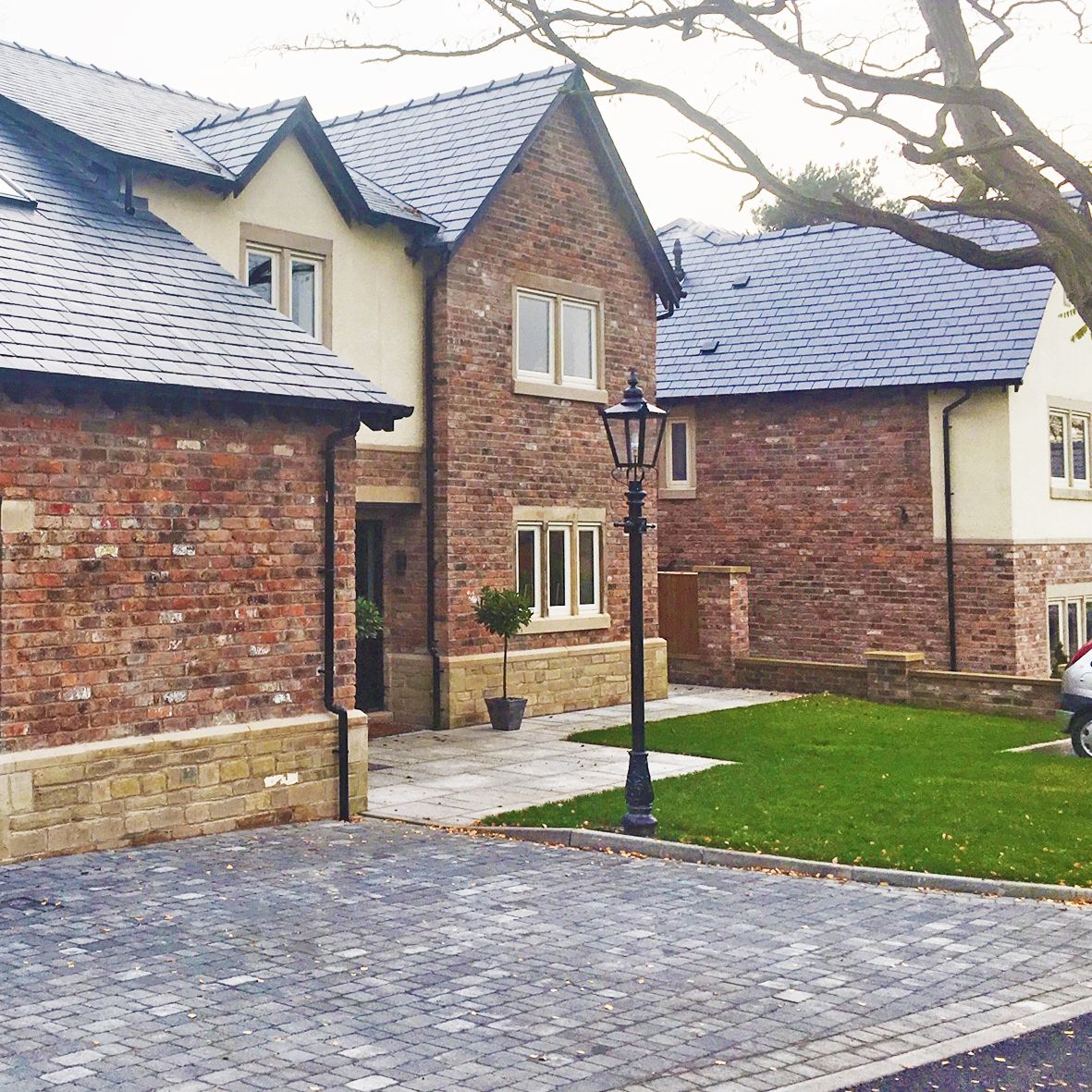 Victorian Lamp post outside brick house in driveway