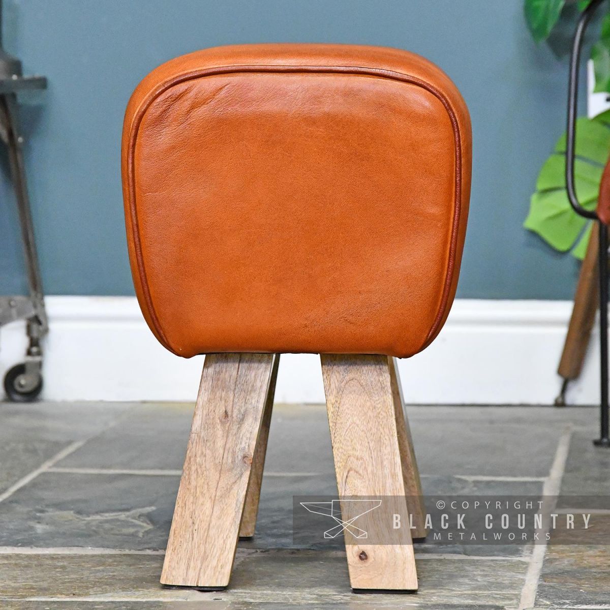 Side View of the Mango Wood & Tan Goat Leather Bug Stool Side View of the Mango Wood & Tan Goat Leather Bug Stool