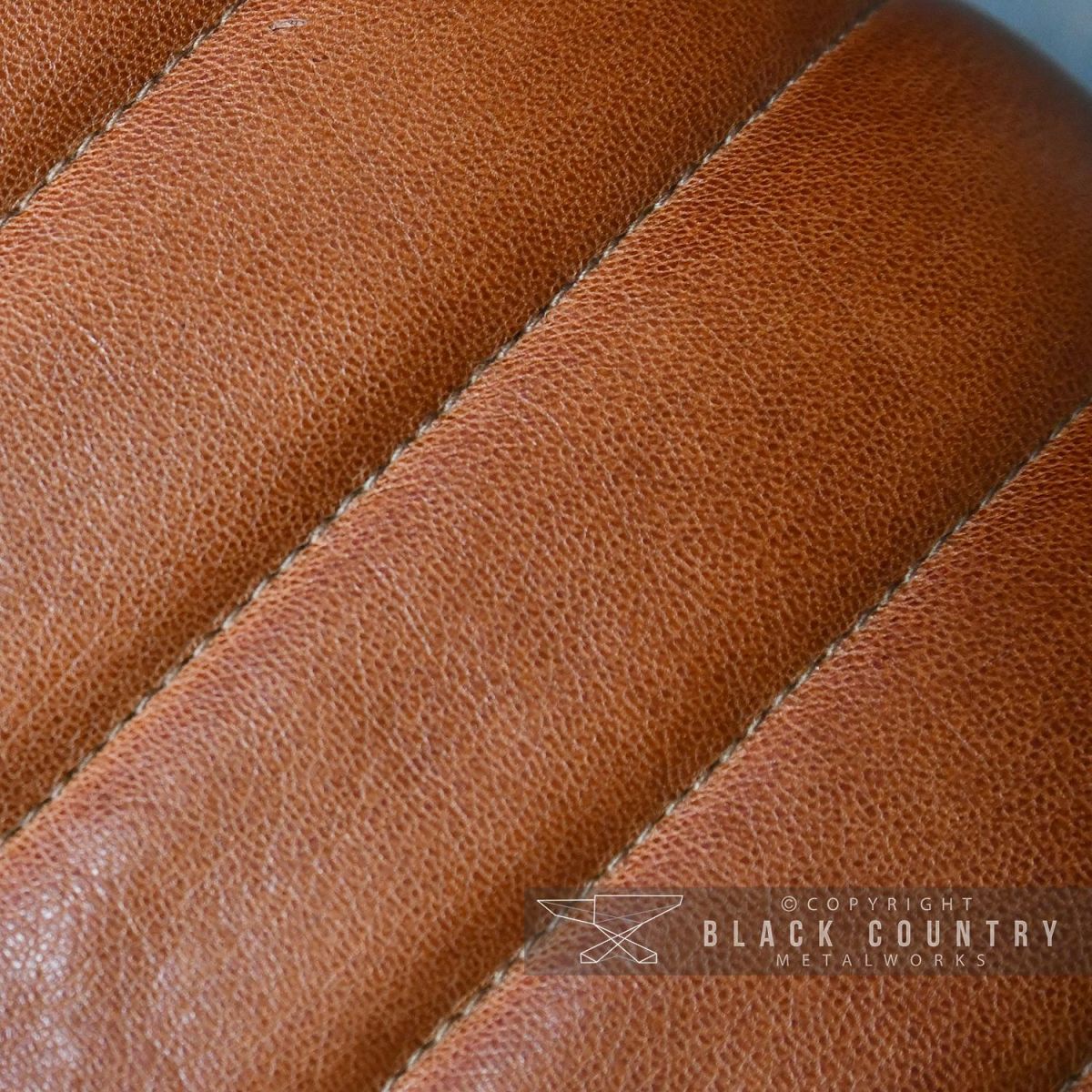 Close-up of the Padded Tan Goat Leather on the Stool Close-up of the Padded Tan Goat Leather on the Stool