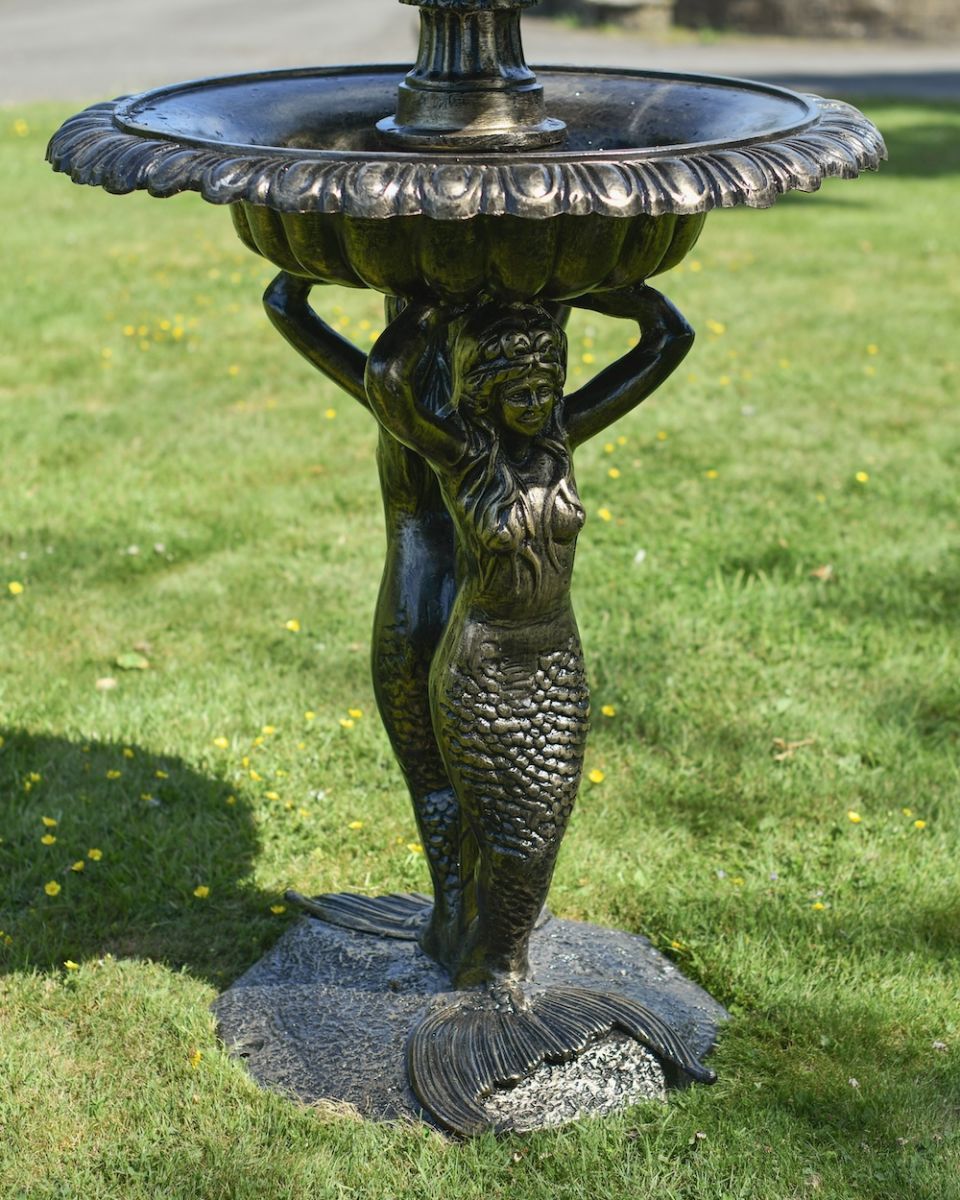 Close up of mermaid detail on 4 tier garden fountain Close up of mermaid detail on 4 tier garden fountain
