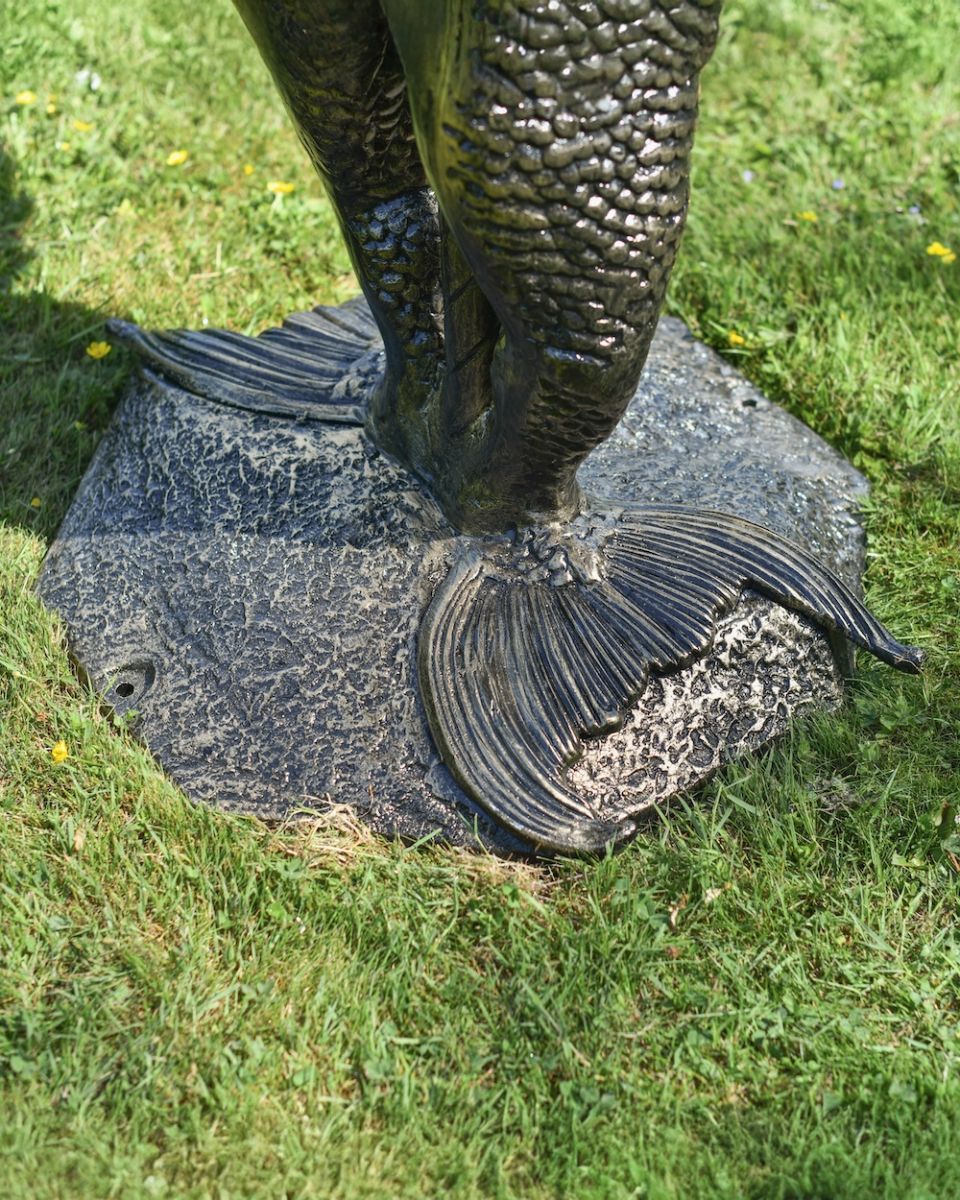 Close up of intricate mermaid tail detail on 4 tier garden fountain Close up of intricate mermaid tail detail on 4 tier garden fountain