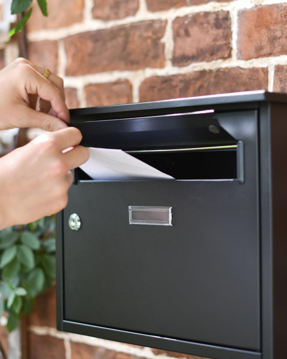 Scale Shot of Posting Letters on Modern Black Steel Front Opening Wall Mounted Post Box with Lock