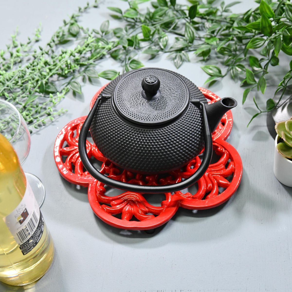Red Cast Iron Flower Petal Trivet in Use with Teapot Red Cast Iron Flower Petal Trivet in Use with Teapot