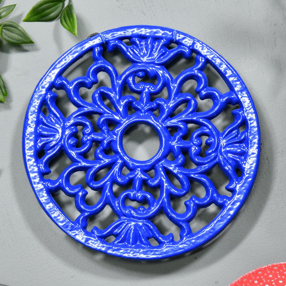 Blue Round Cast Iron Trivet on Grey Surface