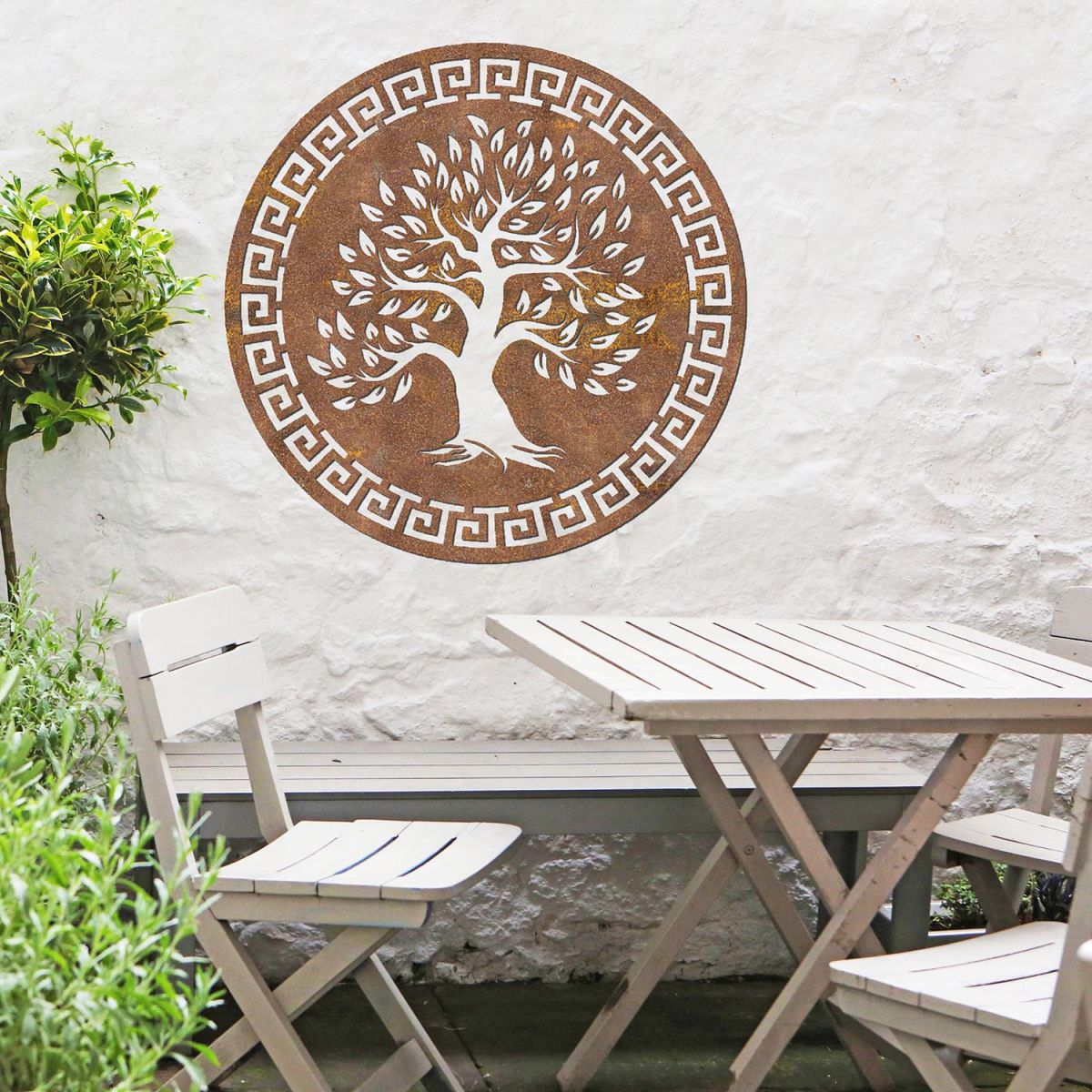 Round "Olive Tree" Wall Art in the Garden Above a Wooden Table and Chair Set