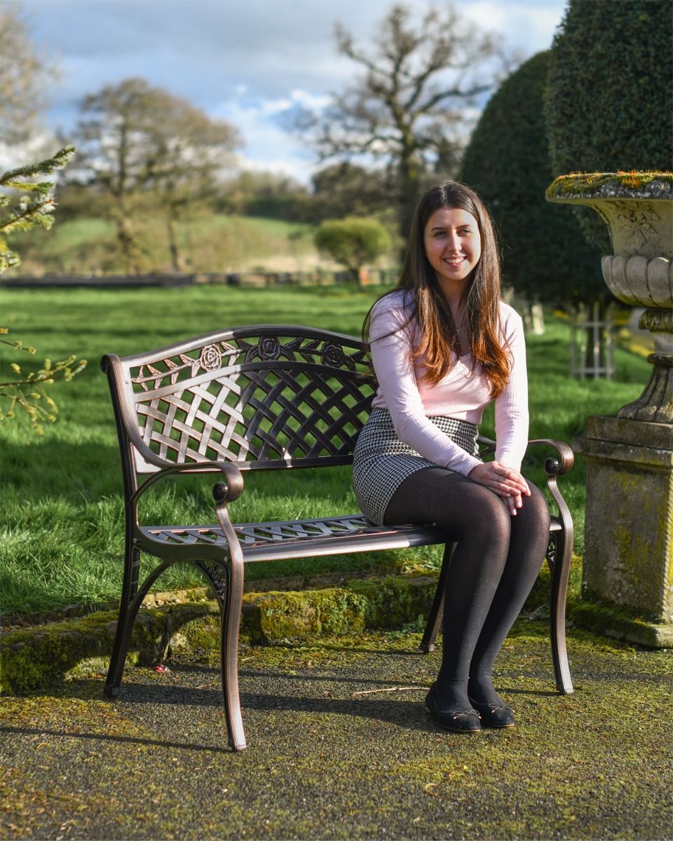 Woman sat on Brushed Copper "Thornton" Two Seater Garden Bench 