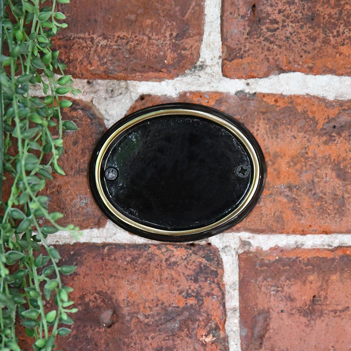 Polished Brass & Black Oval House Number Sign in Use Outdoors on a Wall