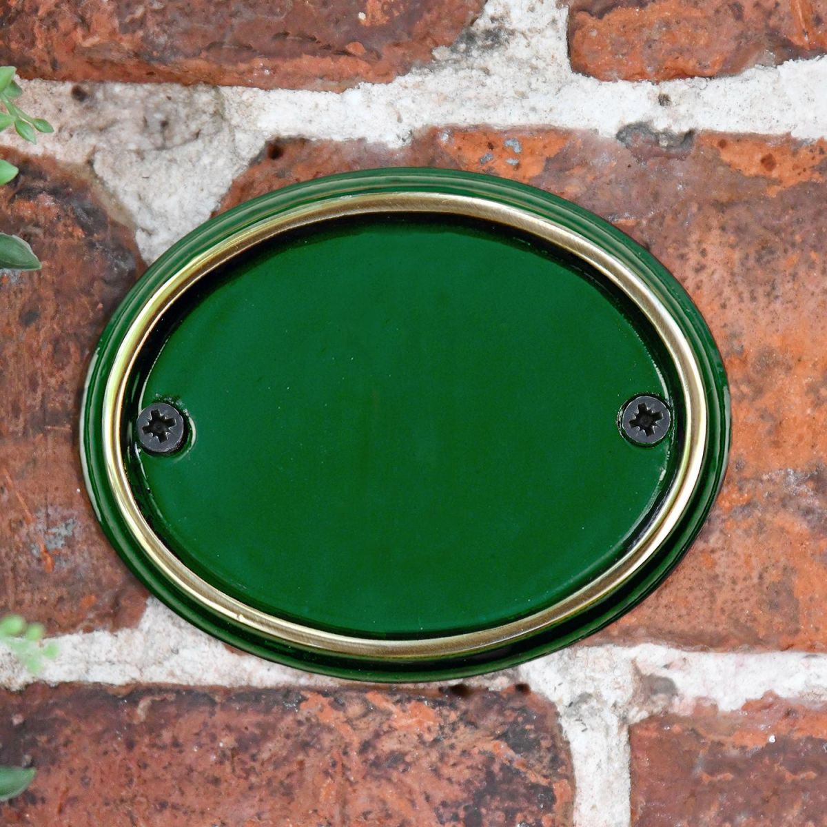Polished Brass & Green Cast Oval House Number Sign on a Brick Wall Polished Brass & Green Cast Oval House Number Sign on a Brick Wall