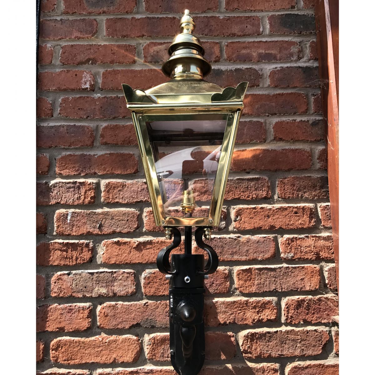 View of the Front of the Polished Brass Harrogate Wall Lantern on Bracket on a Brick Wall