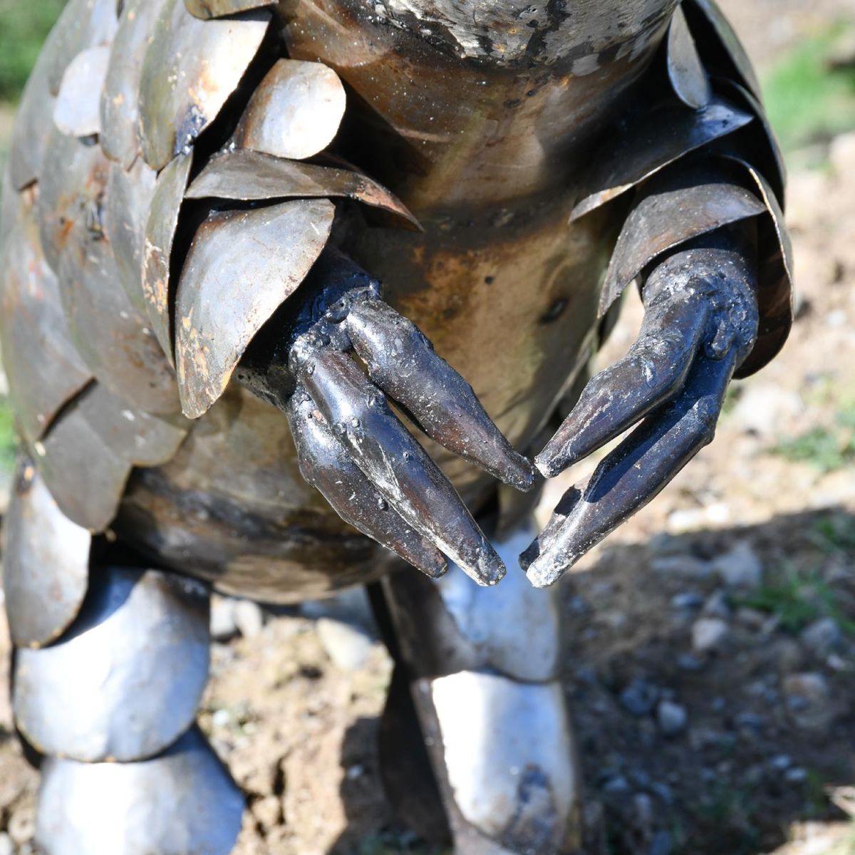 Close-up of the hands on the Recycled Metal Pangolin Sculpture