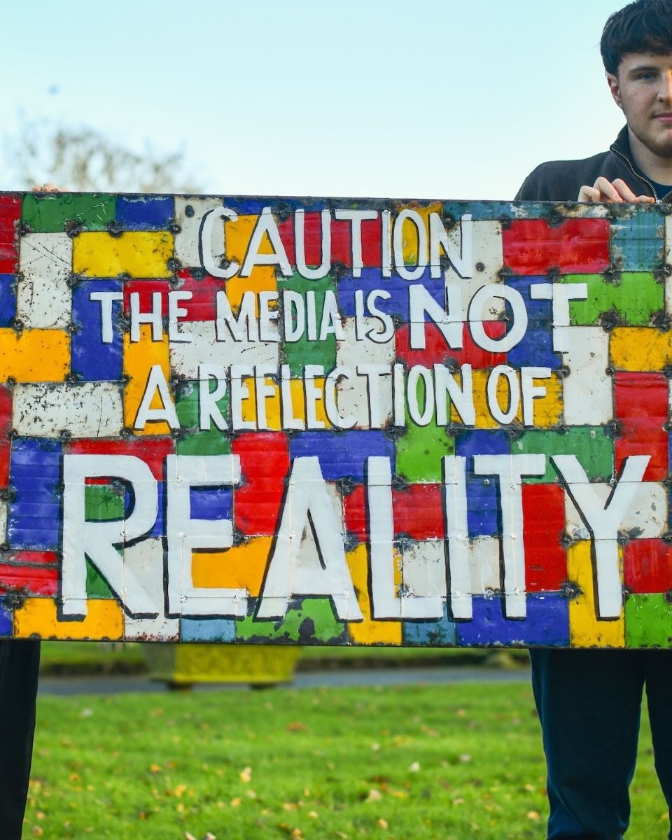 Recycled Oil drum wall art caution the media is not a reflection of reality close up centre