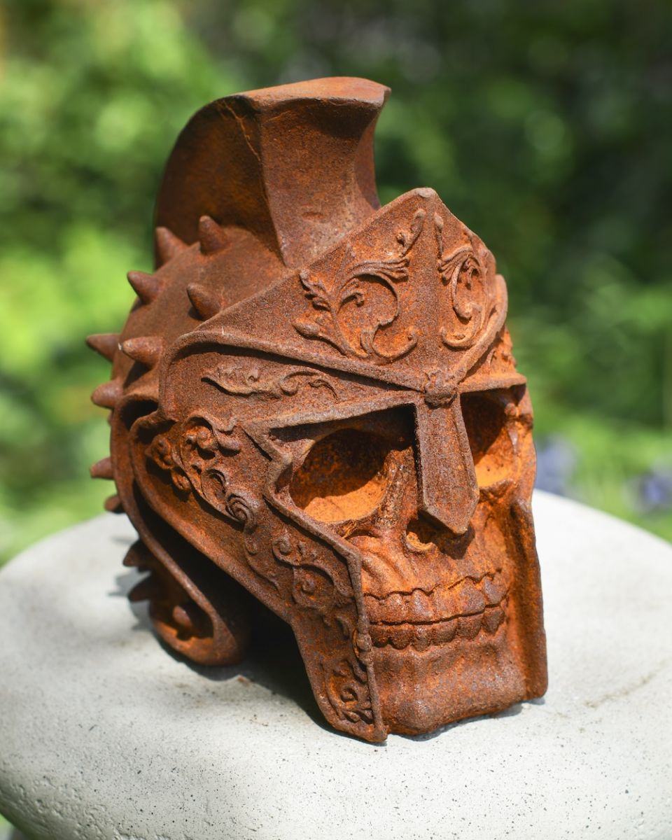 Rusted cast iron gladiator skull garden ornament