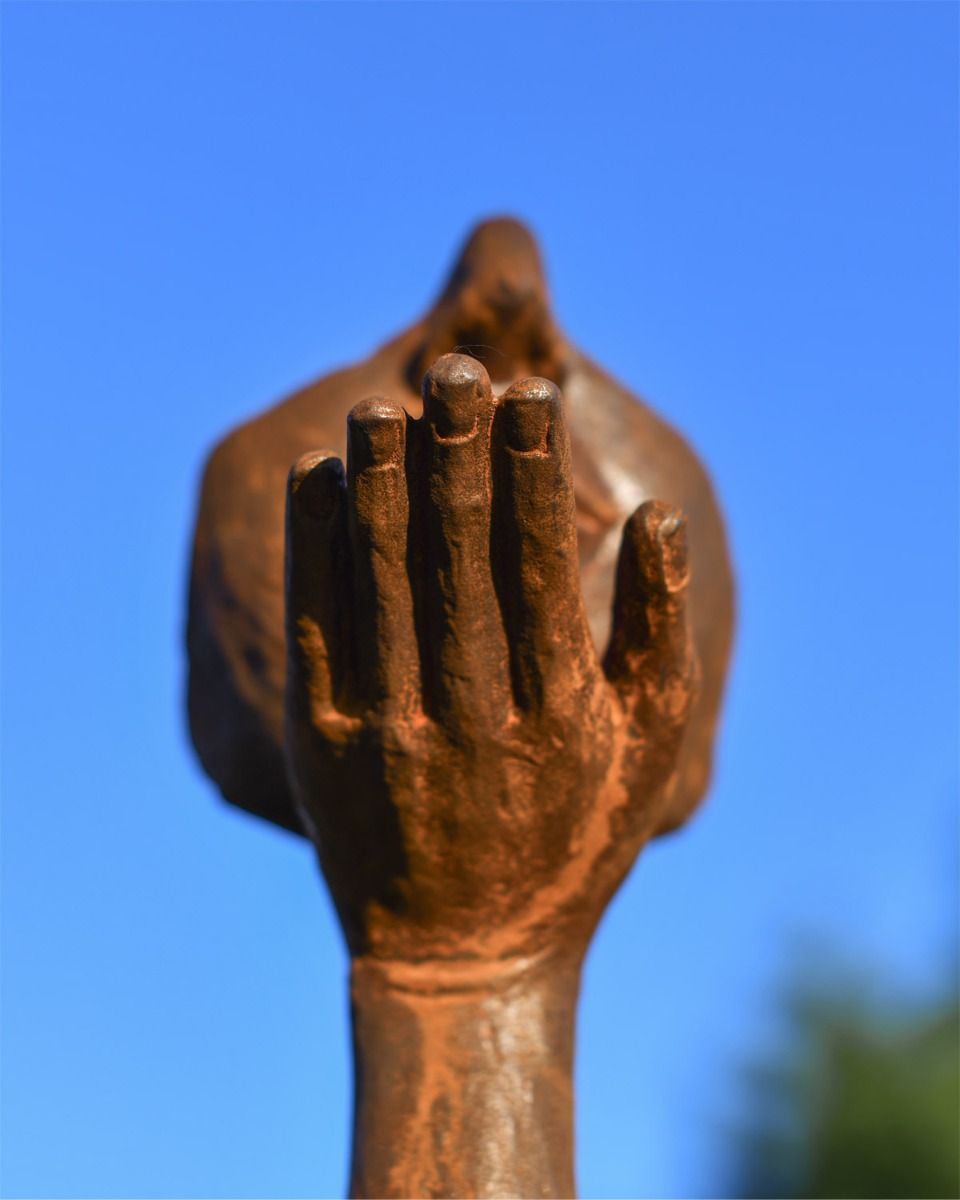 Close Up of Rustic Cast Iron Blowing a Kiss Garden Sculpture