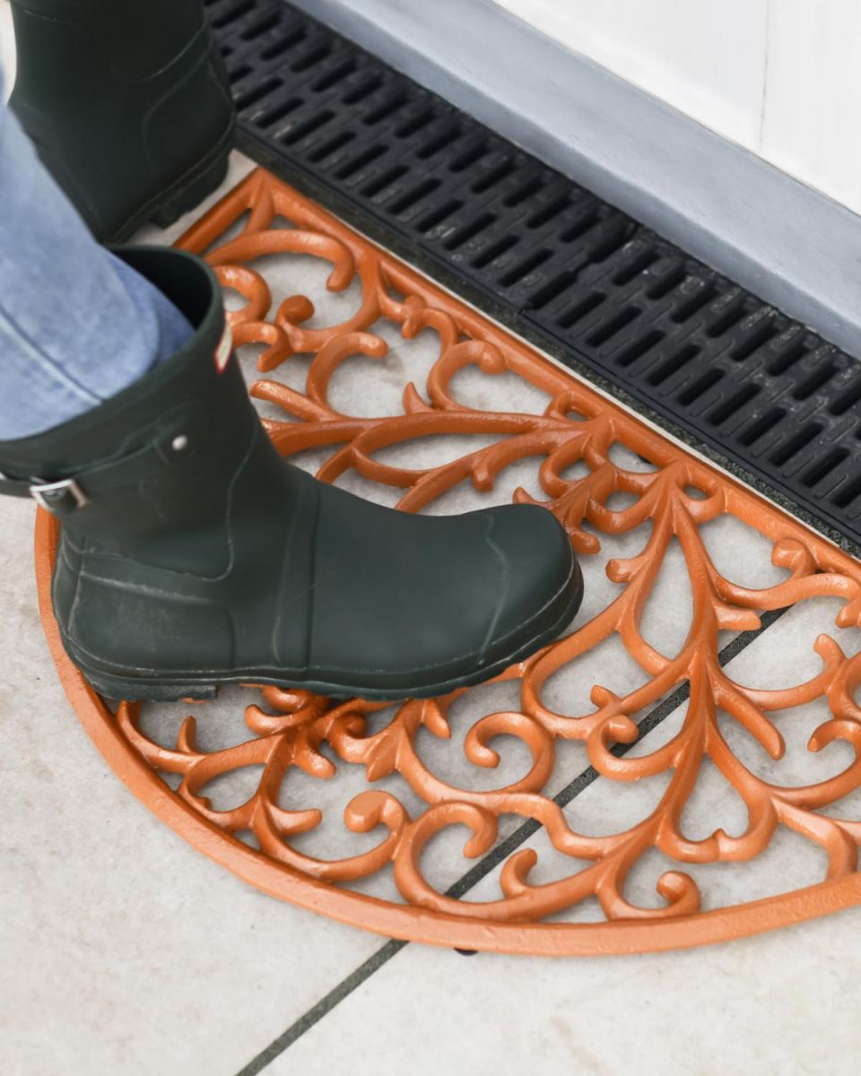 Scale Shot of Rustic Cast Iron Ornate "Sunrise" Semi Circle Door Mat