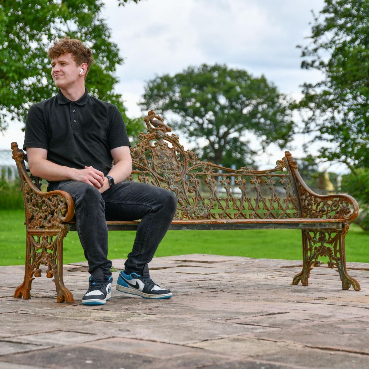 Rustic Cast Iron Three Seater Garden Bench with Male for Scale 
