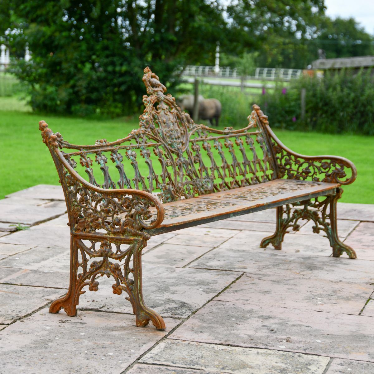Side view of rustic cast iron three seater gothic bench 