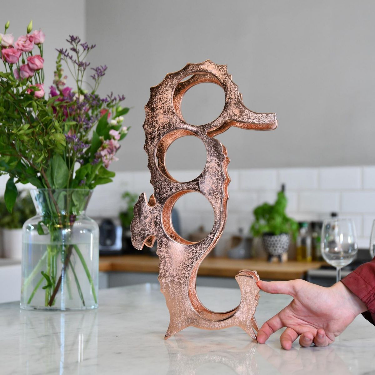Copper "Seahorse" Wine Rack with hand for scale 