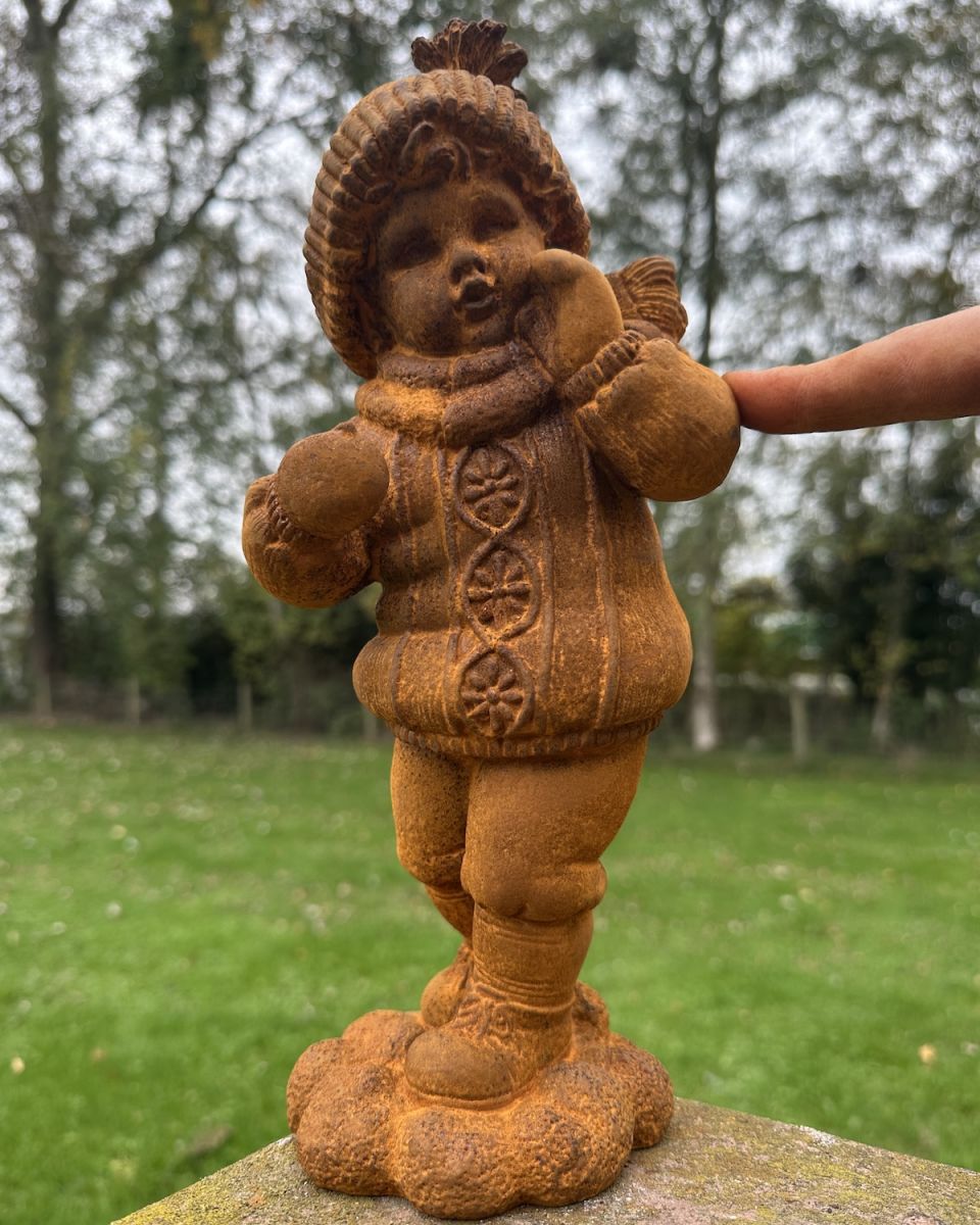 Scale image of rustic cast iron girl in winter clothes outdoor sculpture