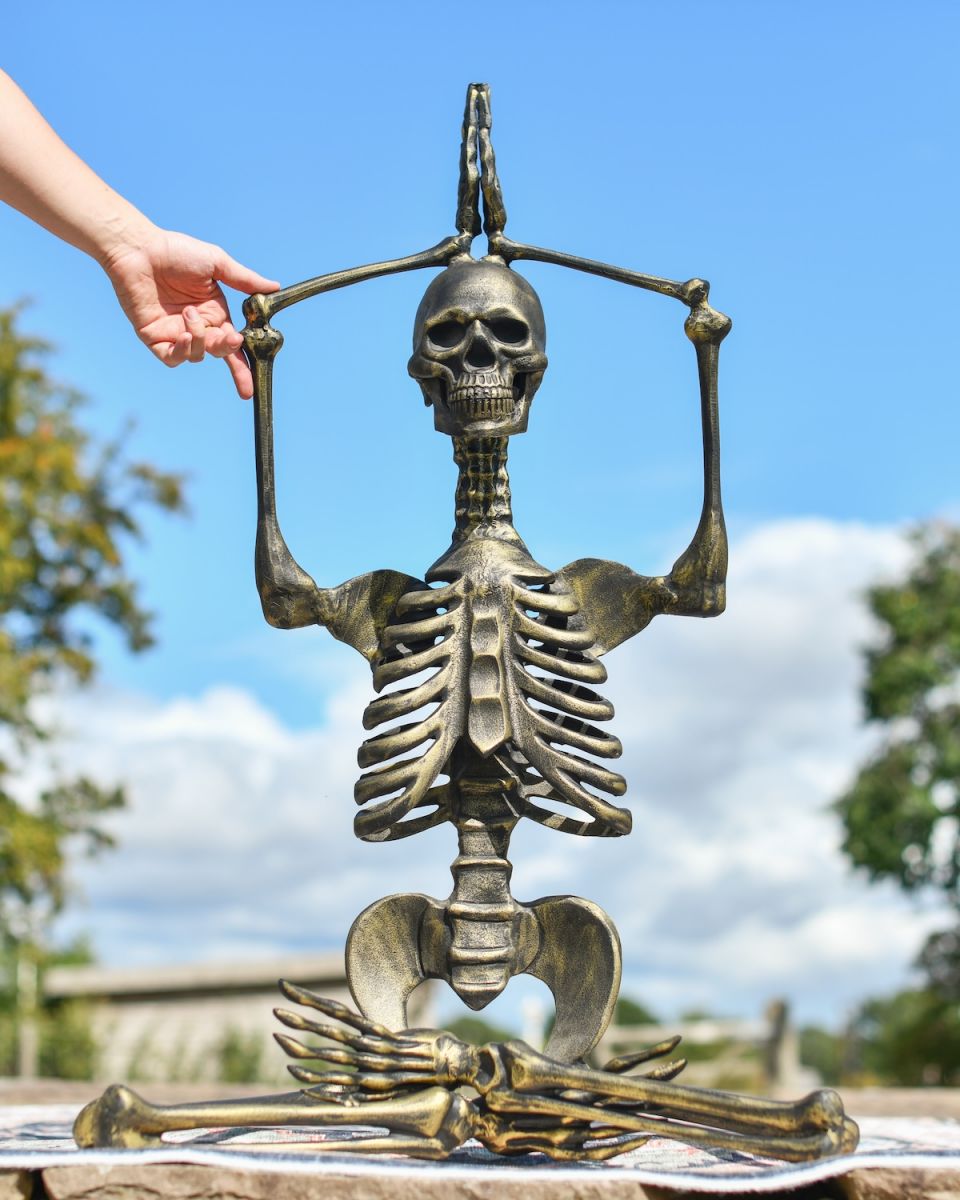 Scale image of brushed gold skeleton garden statue