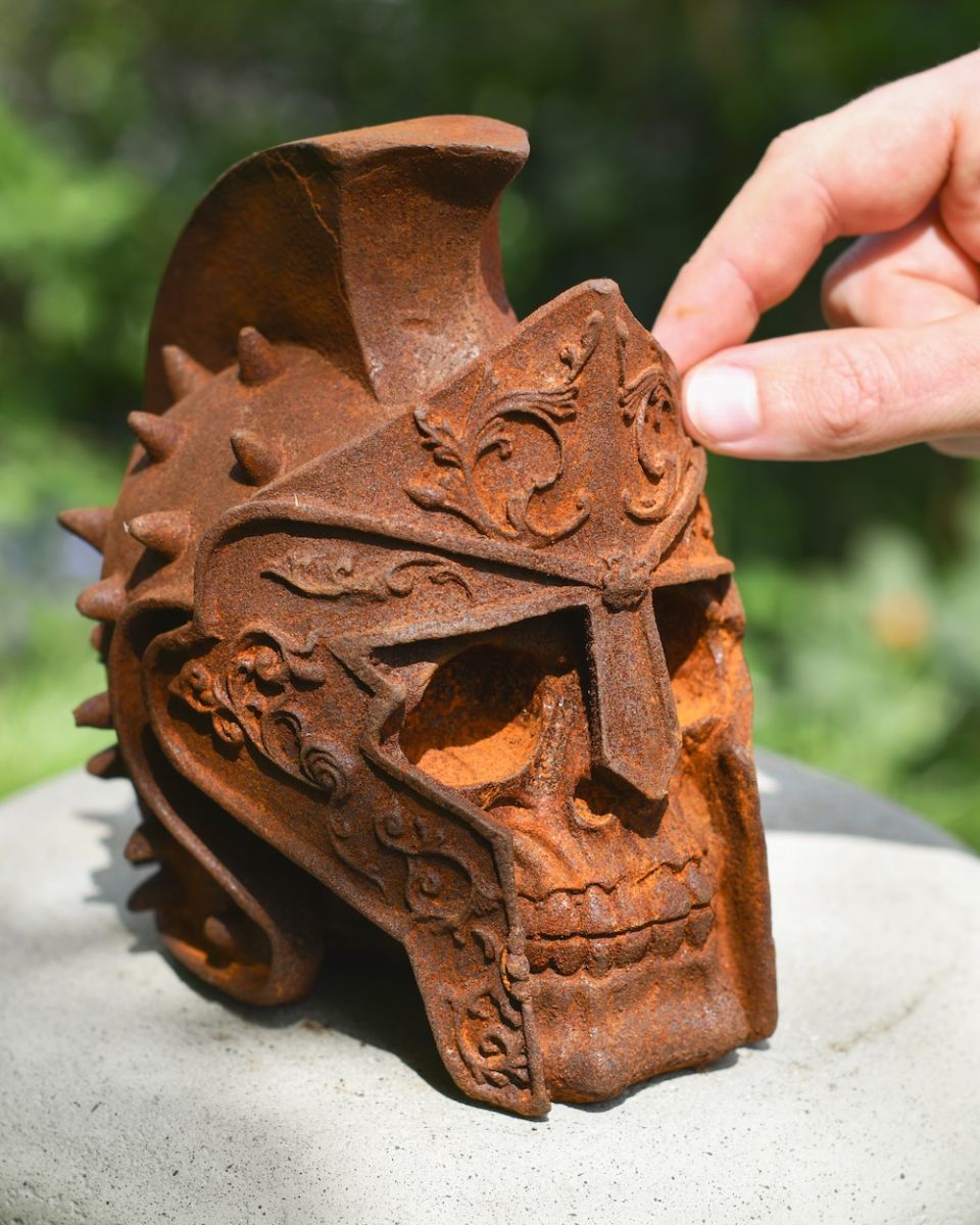 Scale image of rusted gladiator skull garden ornament