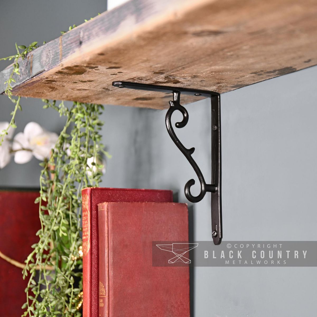 Black Scroll Shelf Bracket in Situ Holding a Wooden Shelf