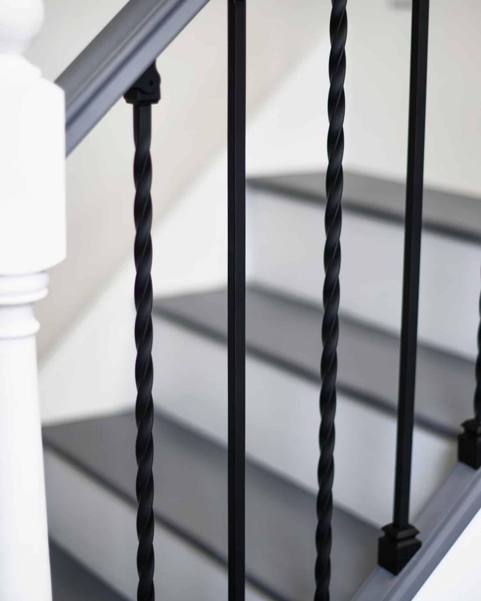 Close-Up of Set of 2 Matte Black "Enfield" Steel Stair Spindles - Pattern 11 in Situ Close-Up of Set of 2 Matte Black "Enfield" Steel Stair Spindles - Pattern 11 in Situ
