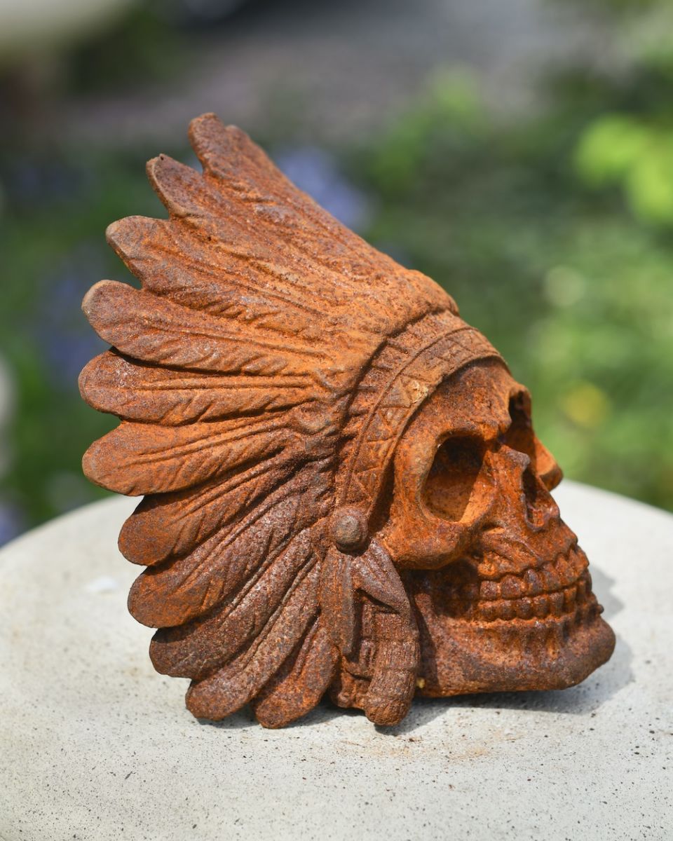 close up side profile of skull in headdress garden ornament