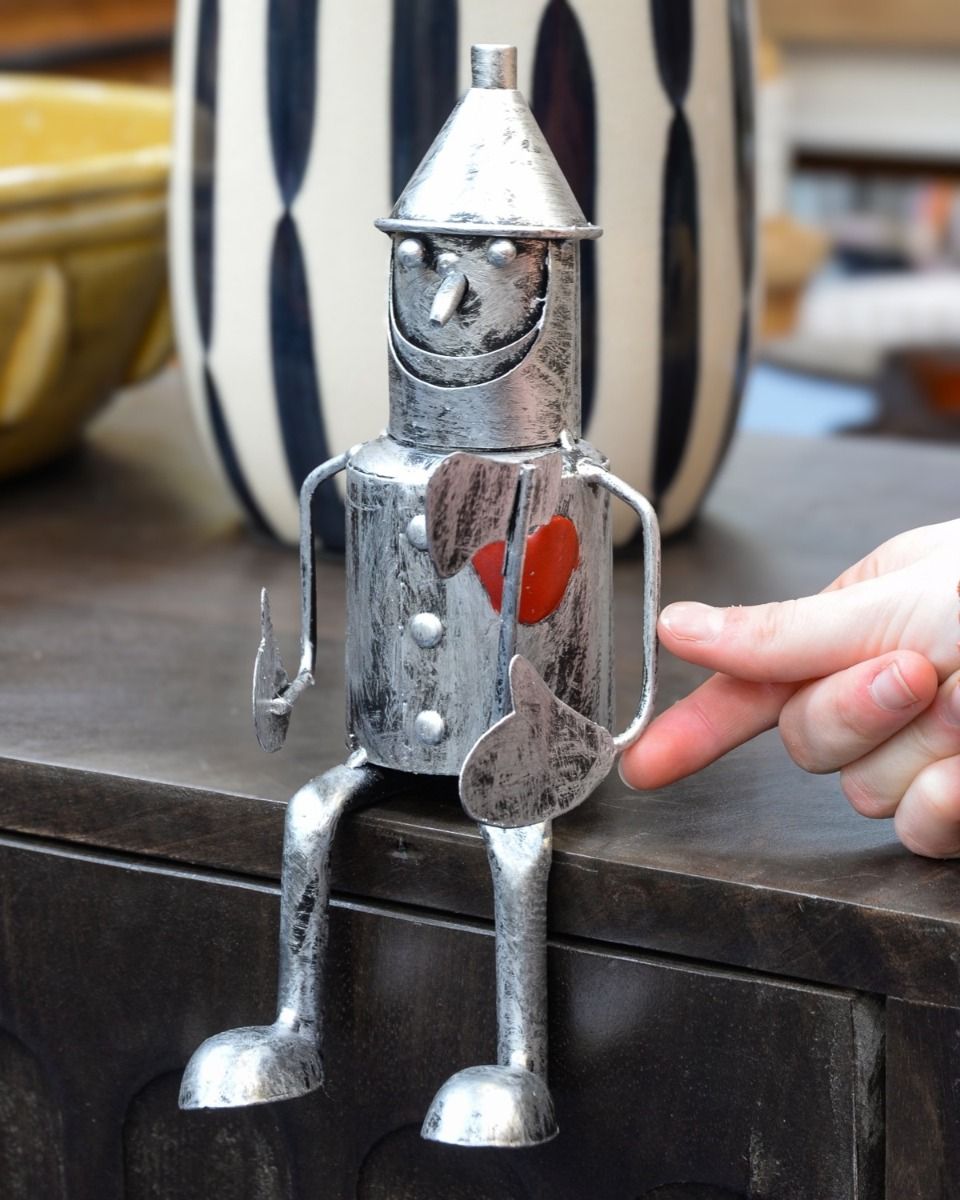 "Rusty" the Tin Man Sitting Garden Ornament Positioned on the Edge of a Table with Hand in Shot for Scale