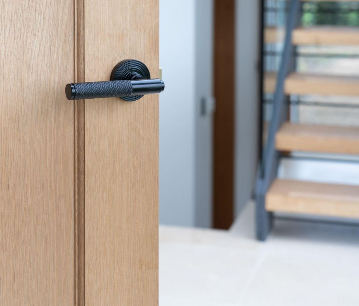 Sleek Black Textured Unsprung Lever Door Handle on Beehive Rose on Door