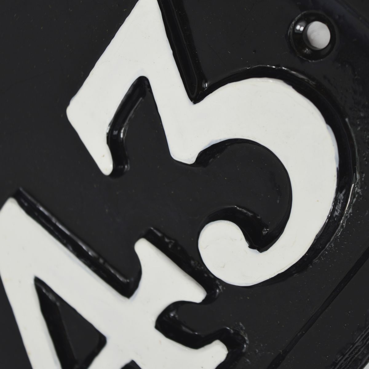 Close up of hand painted house numbers and screw holes