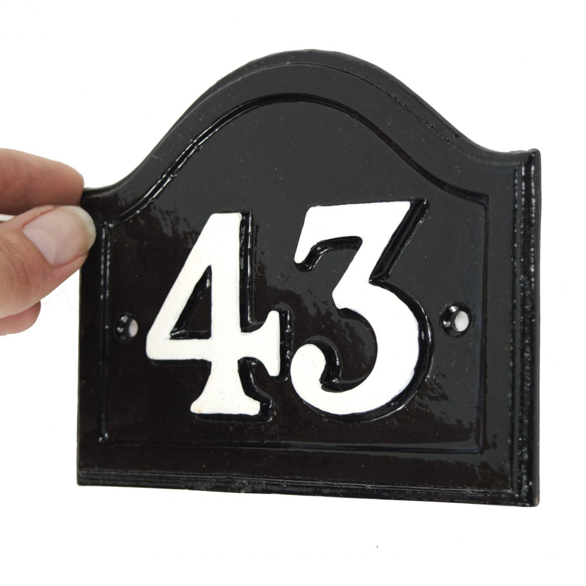 scale image of black and white cast Iron arched house number plaque