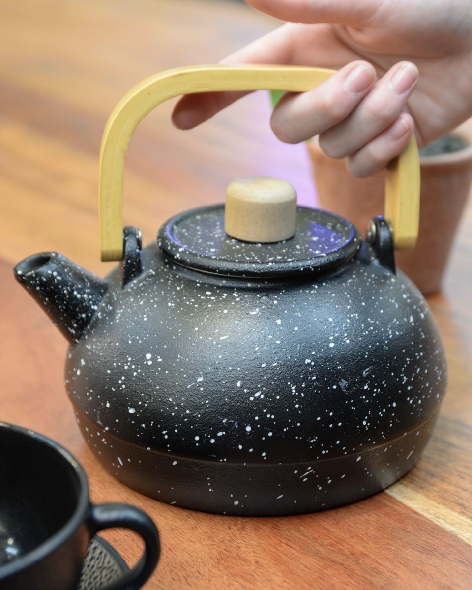 "Ginga" Cast Iron Japanese Style Teapot in Black with Hand in Shot for Scale