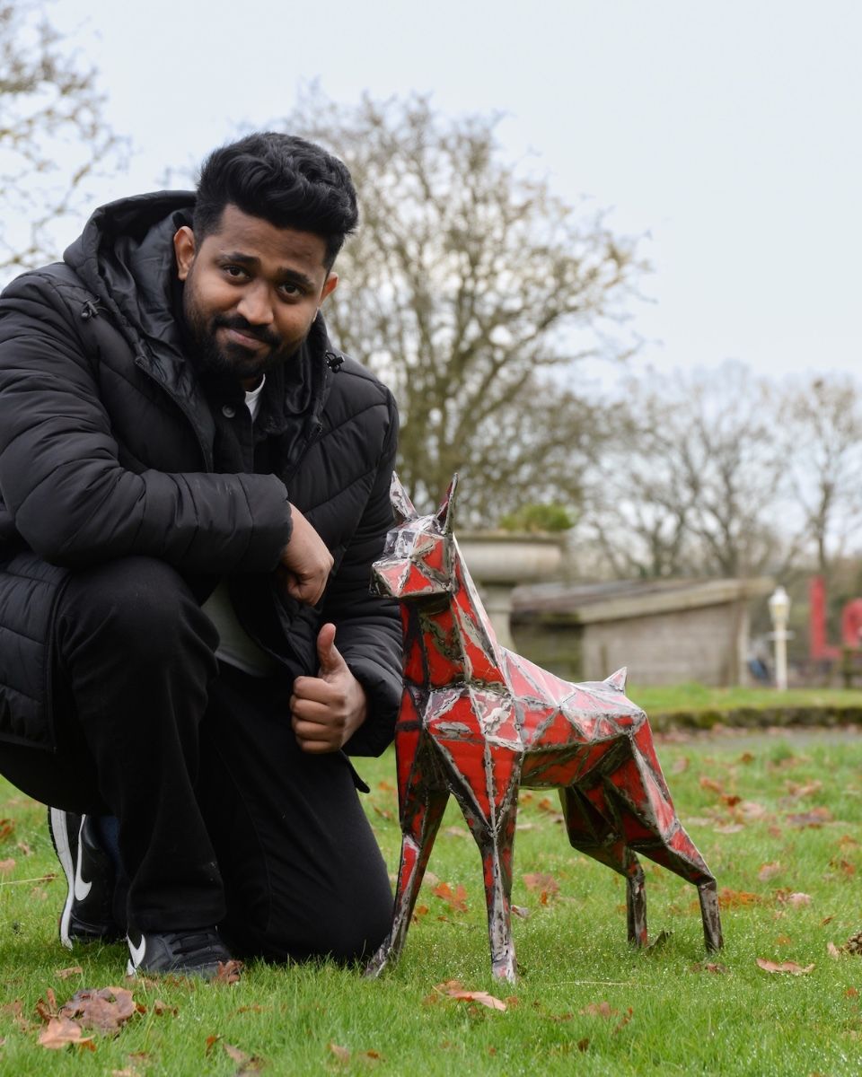 ‘Spark’ Upcycled Oil Drum Garden Sculpture with man crouching next to sculpture