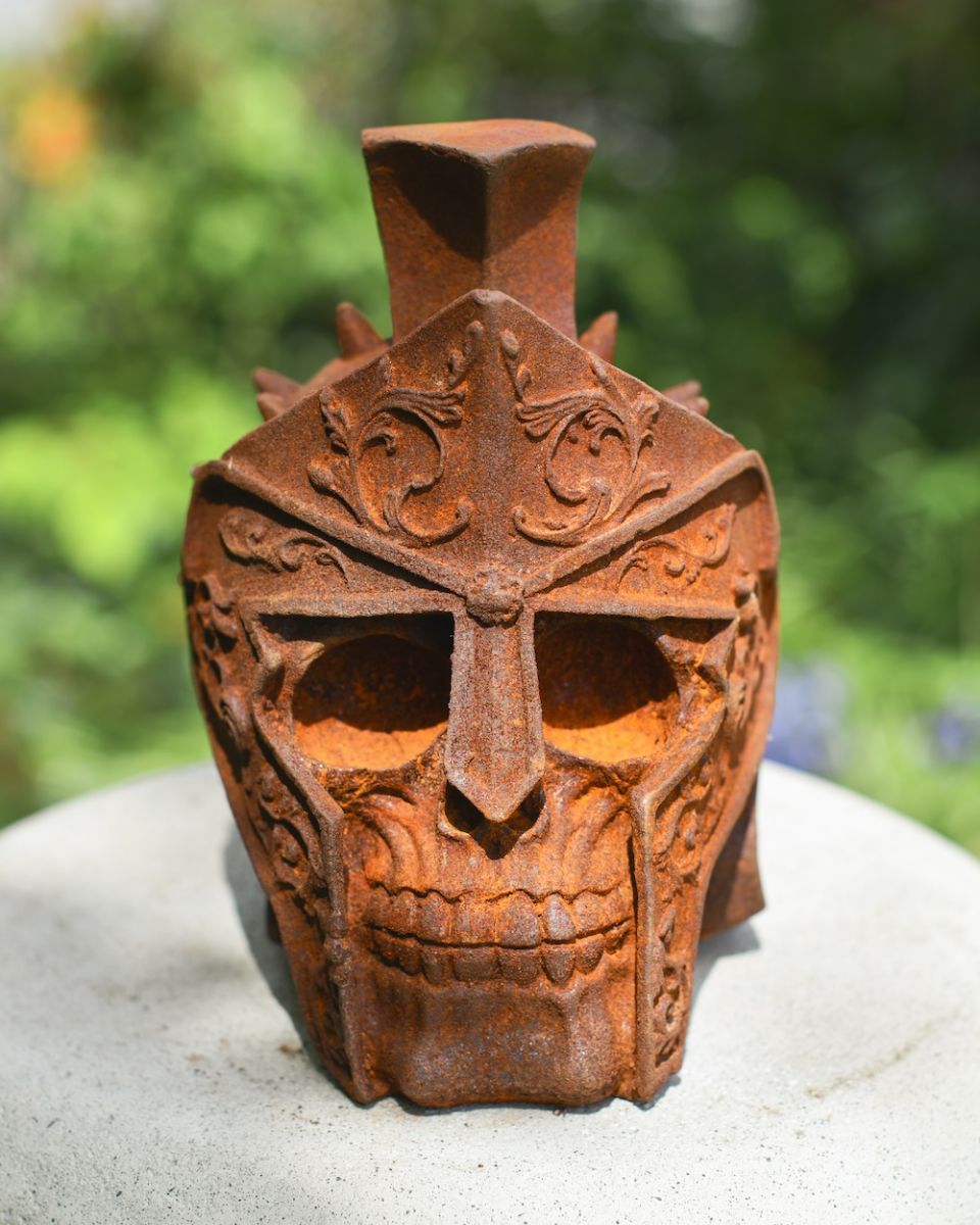 front view of rusted gladiator skull garden ornament