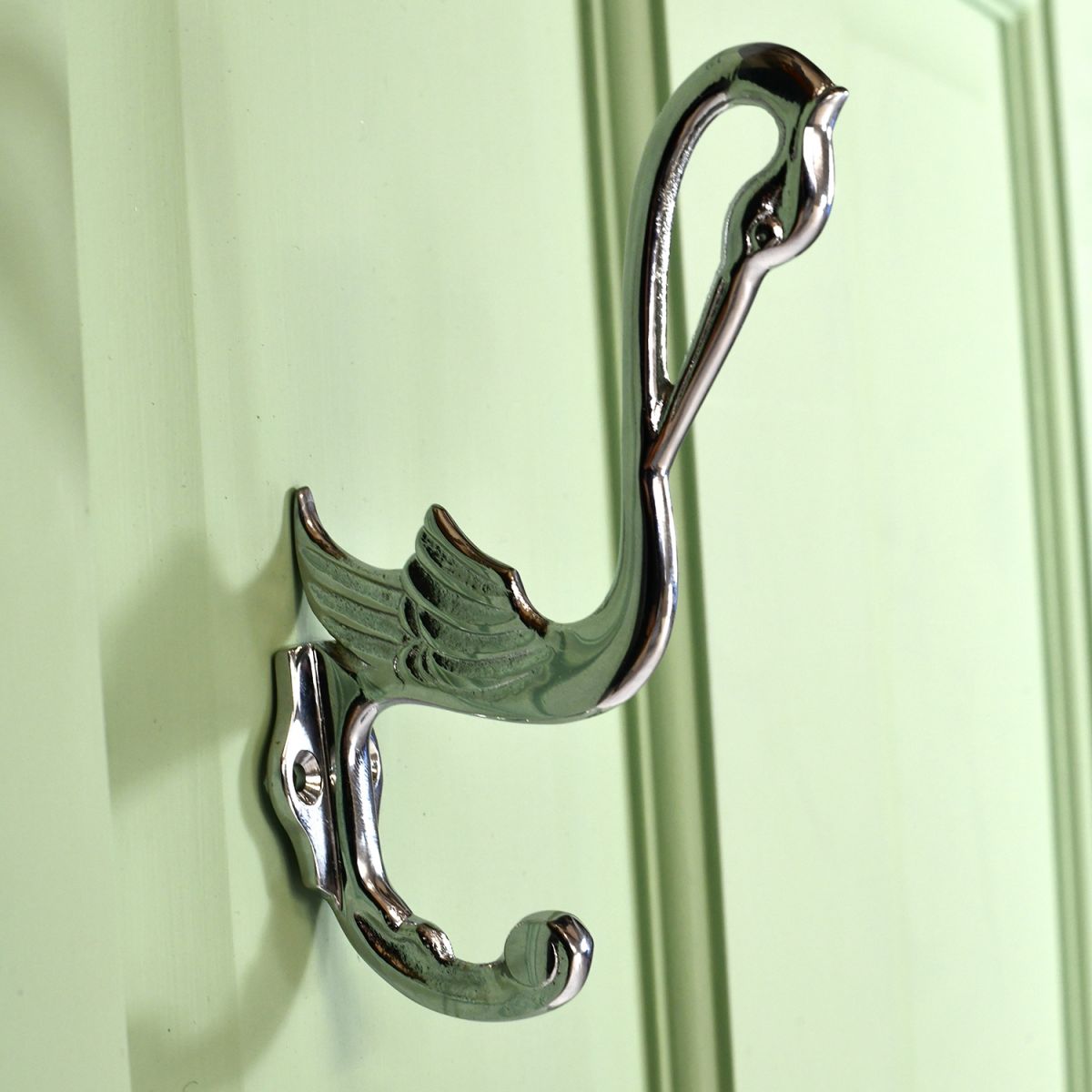 Bright Chrome Swan Coat Hook on a Green Surface