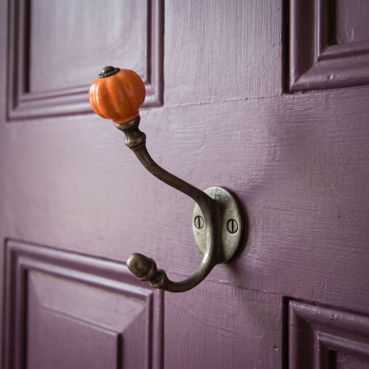 The 125mm Ironmonger Acorn Orange Ceramic Coat Hook Shown on a. Purple Painted Door - Digital Illustration
