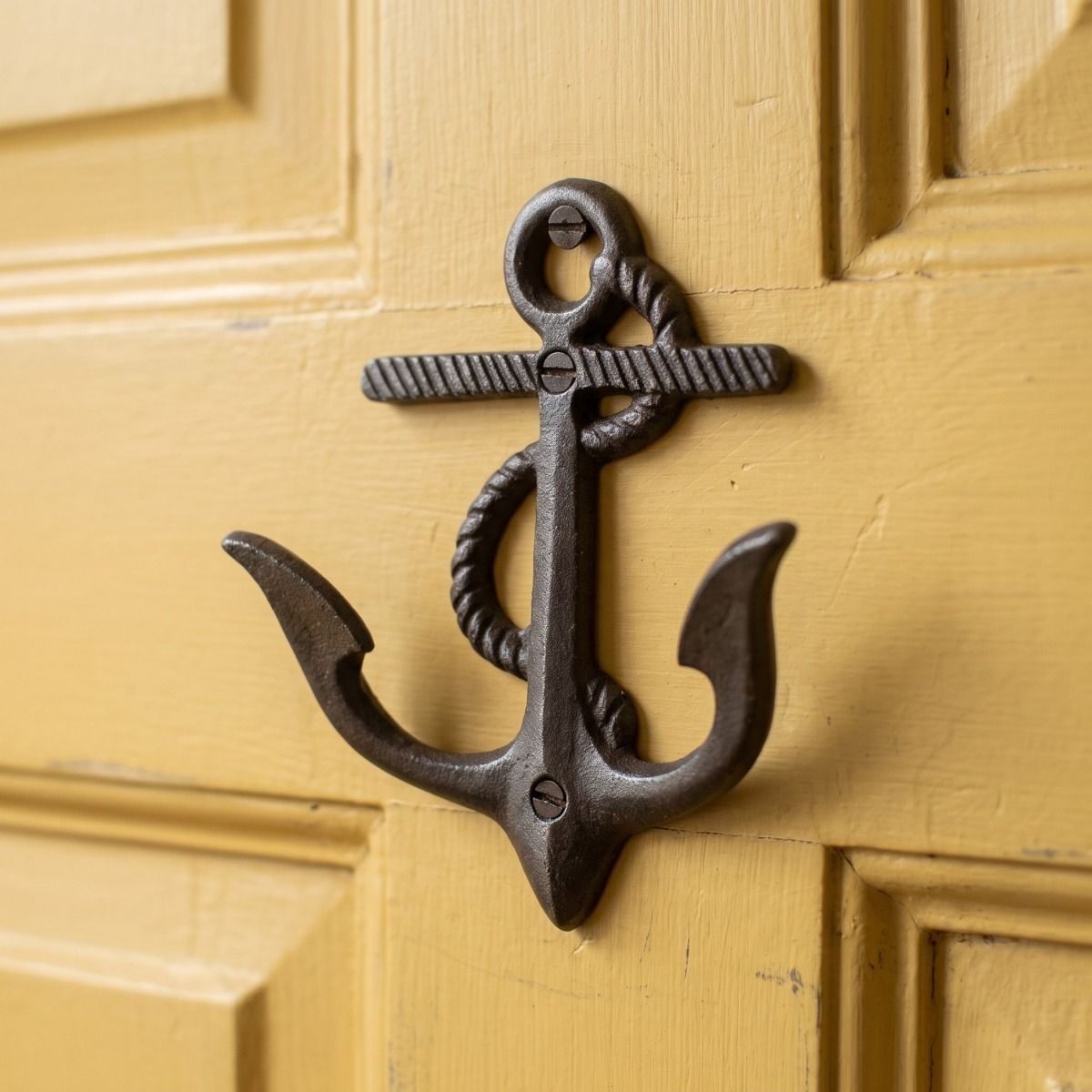 The 130mm Maritime Double Anchor Rope Coat Hook in Antique Iron Shown Mounted on a Yellow Interior Door - Digital Illustration