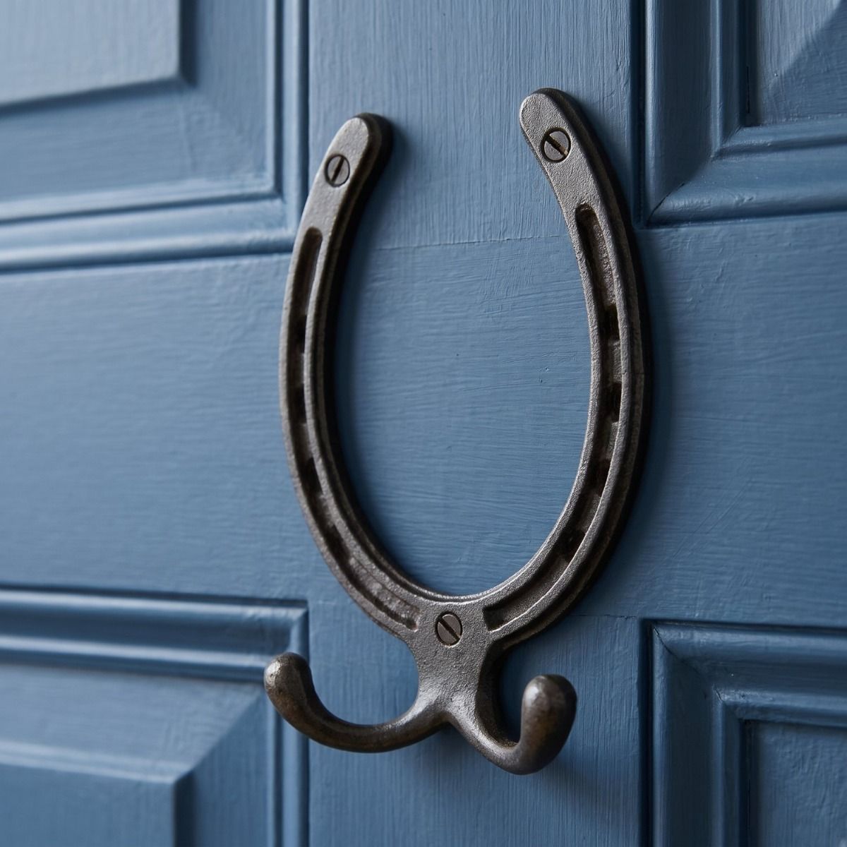 The Blacksmith Vintage Cast Iron Horseshoe Robe Hook Mounted onto a Blue Door - Digital Illustration