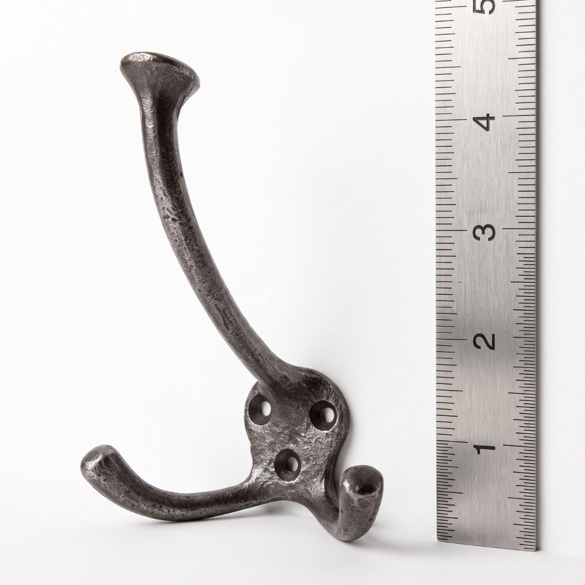 The Cotswold Flared Tip Triple Prong Wall Hook - 125mm on a White Background next to a Steel Ruler for Scale - Digital Illustration
