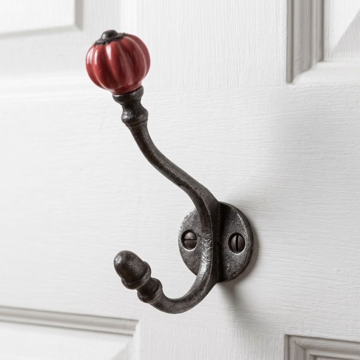 The Ironmonger Acorn Rose Red Ceramic Coat Hook - 125mm Shown Mounted onto a White Coloured Door - Digital Illustration