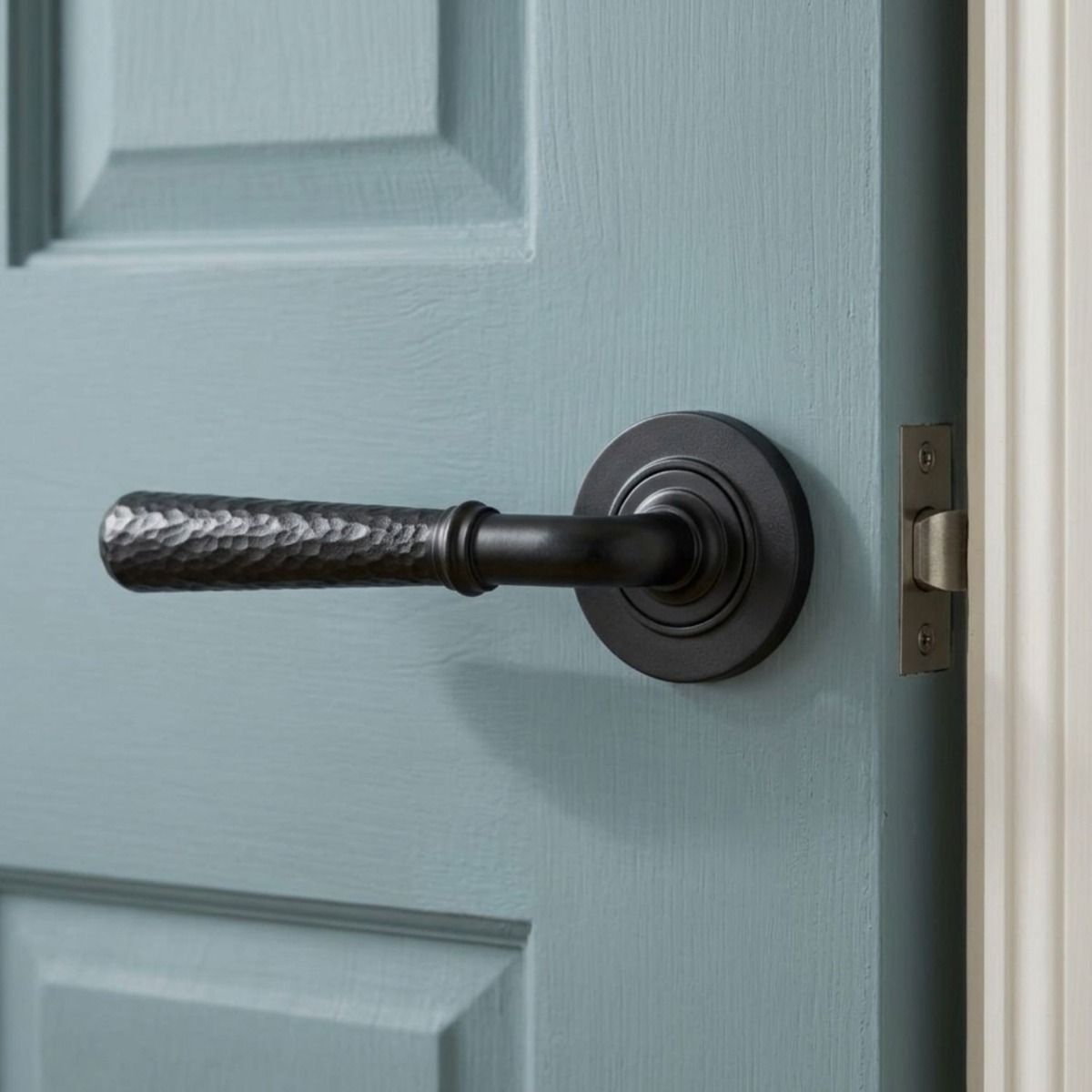 The Kenley Gardens Matte Black Hammered Unsprung Lever Door Handle on Rose On a Light Blue Door in a Coastal Cottage Setting - Digital Illustration