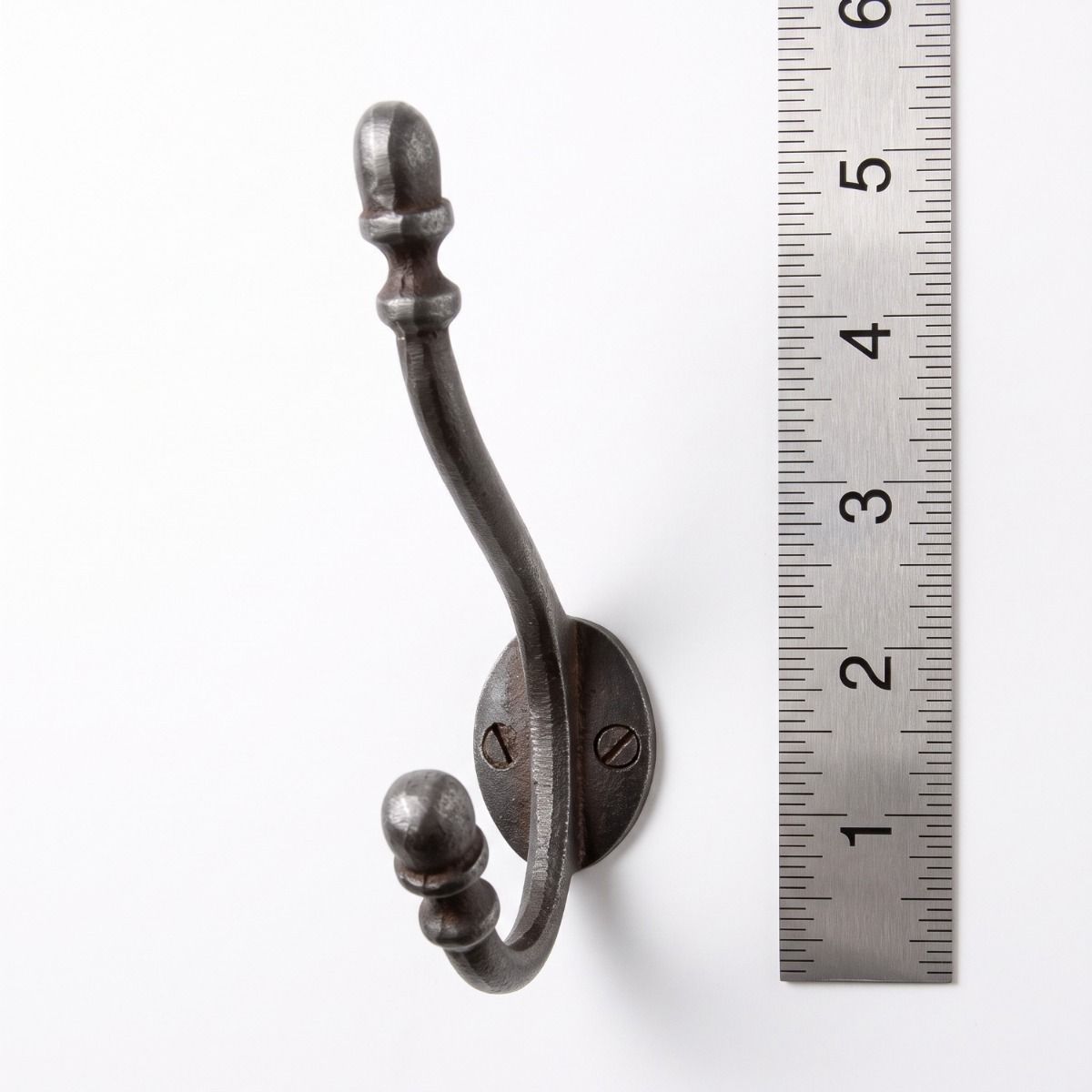 The Regency Oval Backplate Acorn Hook - 130mm on a White Background next to a Steel Ruler for Scale - Digital Illustration
