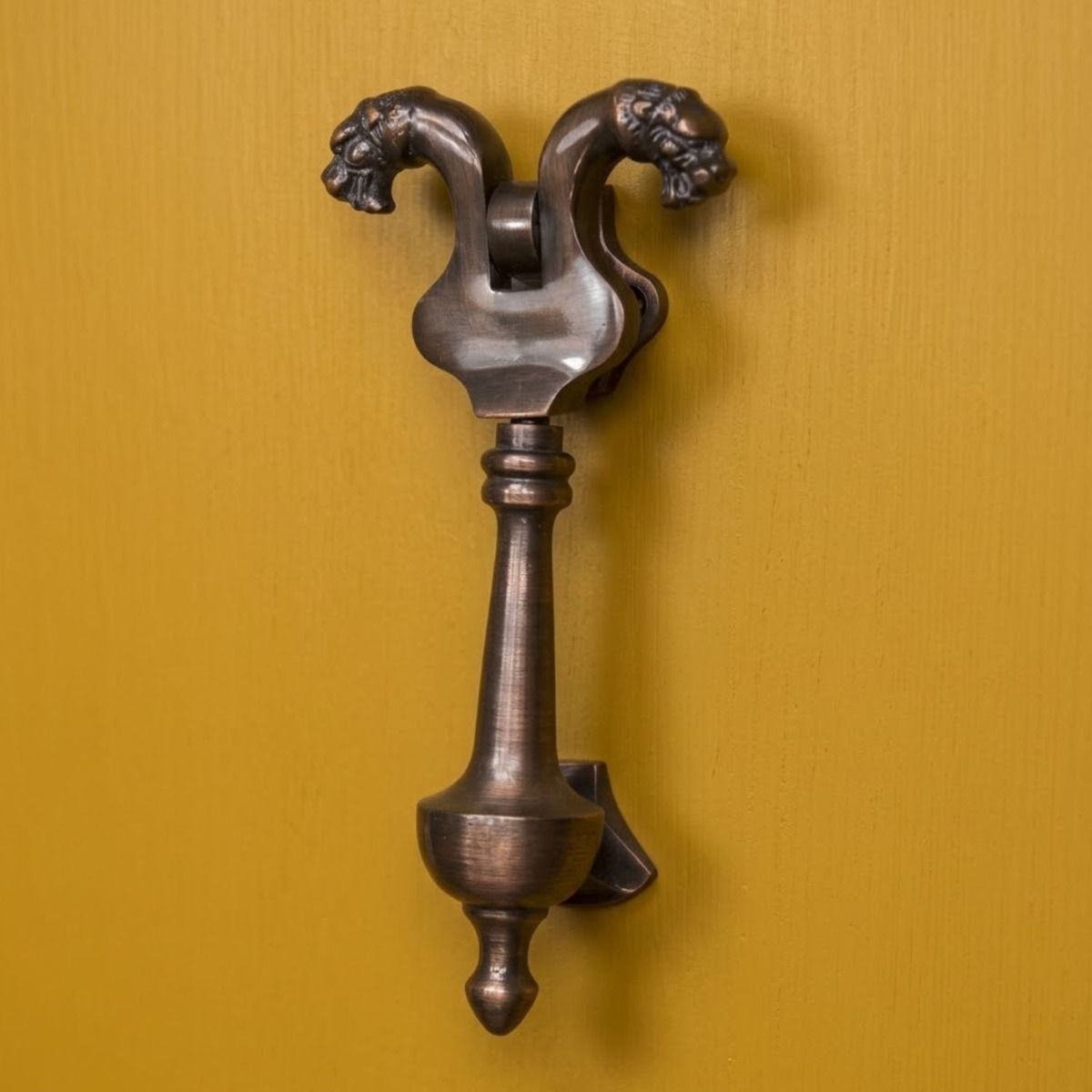 The Salvador Antique Copper Saber Tooth Door Knocker on a Bright Yellow Door on a Contemporary Home - Digital Illustration