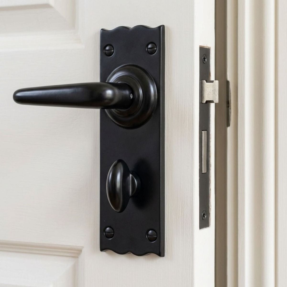 The Traditional Black Bathroom Mortice Lock Door Handle Set Shown Mounted on a White Bathroom Door - Digital Illustration